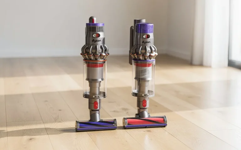 Les aspirateurs sans fil Dyson V8 et V10 sont posés côte à côte sur un parquet lumineux près d’une fenêtre, avec des reflets subtils sur le sol.