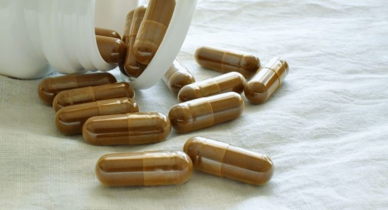 Capsules de complément alimentaire renversées d'un flacon