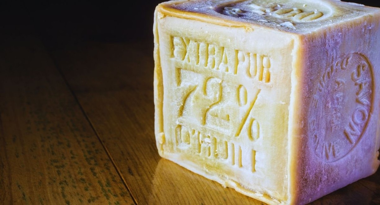Cube de savon de Marseille extra pur posé sur une table en bois